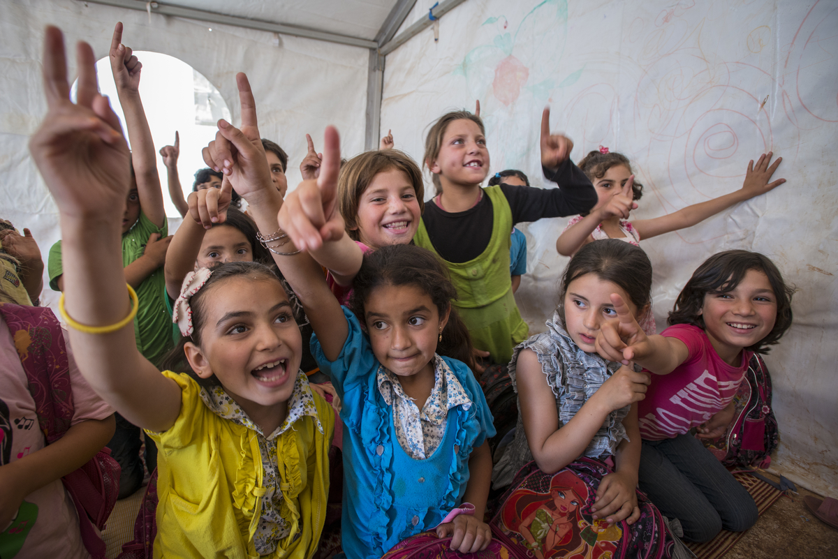 Group of smiling children with hands in the air