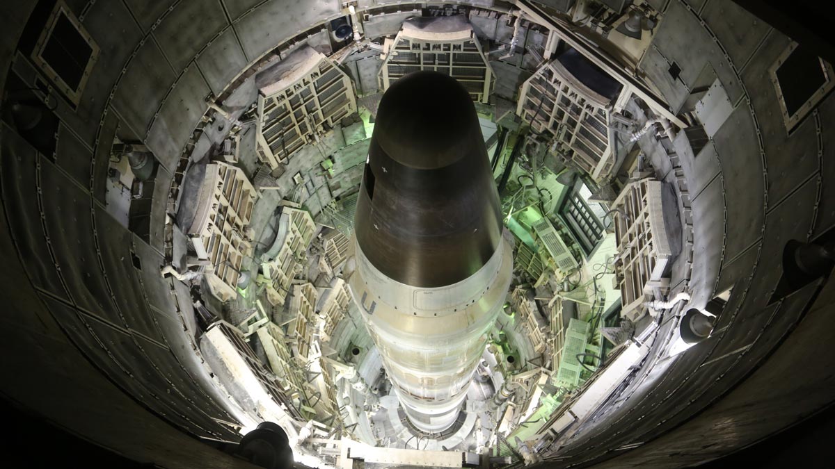 Overhead view of a missile in a missile silo, with surrounding structural and mechanical components.