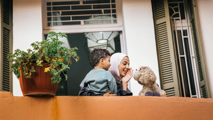 A women, a child and a puppet on a balcony