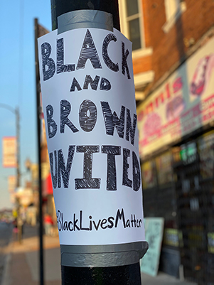 HandDrawnSignOnPostThatReadsBlackAndBrownUnitedBlackLivesMatter