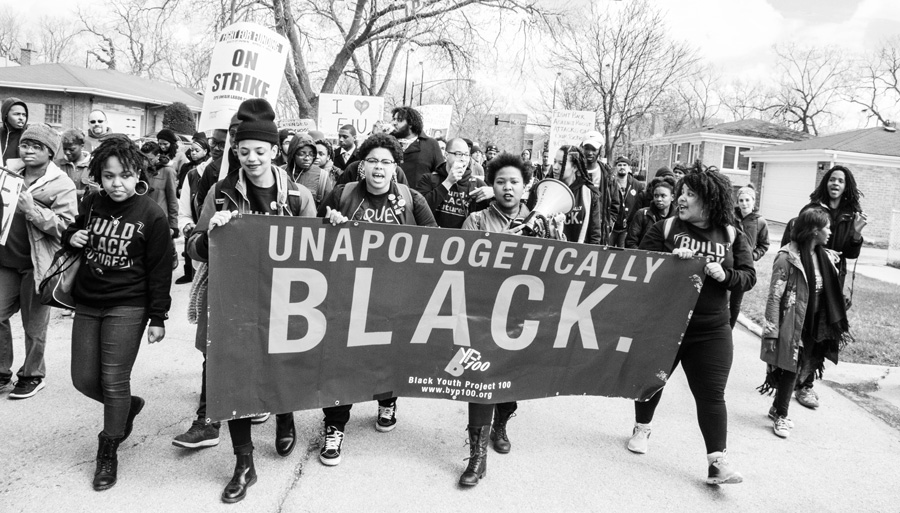 group of youth activists marching with a banner